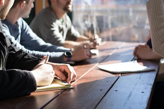 Employee taking notes during company meeting